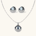 White gold plated spherical jewelry set with zirconia crystal pavé and dark lustrous centers on neutral background.